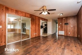 Deltona house for rent - A spacious room with wooden floors and a ceiling fan.