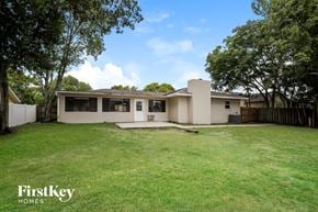 Deltona house for rent - A house with a large lawn and trees in front of it.