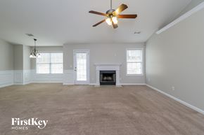 Auburn house for rent - A spacious living room with a fireplace and a ceiling fan.