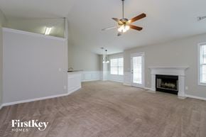 Auburn house for rent - A spacious living room with a fireplace and a ceiling fan.