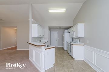 Auburn house for rent - A kitchen with white cabinets and a counter top.
