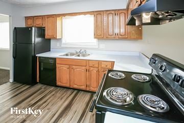 Indianapolis house for rent - A kitchen with wooden cabinets and a black stove top oven.