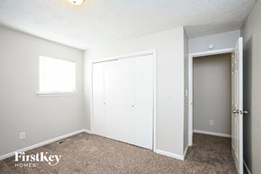 Indianapolis house for rent - A bedroom with a white closet and a window.