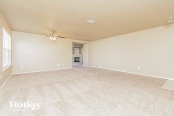 Cedar Hill house for rent - a spacious living room with carpet and a ceiling fan