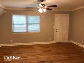 Jacksonville house for rent - an empty room with a ceiling fan and a door
