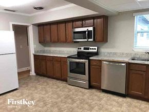 Jacksonville house for rent - a kitchen with stainless steel appliances and wooden cabinets