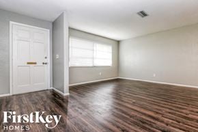 Largo house for rent - the living room of an empty house with wood floors and a white door