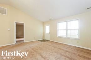 Indianapolis house for rent - the living room of an empty house with carpet and a window
