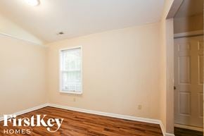 Indianapolis house for rent - a bedroom with a hardwood floor and white walls and a window