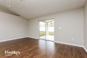 Clermont house for rent - an empty living room with wood flooring and a sliding glass door