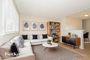Florissant house for rent - A living room with a white couch, a coffee table, and a bookshelf.