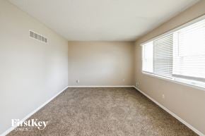 Raytown house for rent - an empty room with carpet and a large window