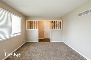 Raytown house for rent - an empty living room with a large window and carpet