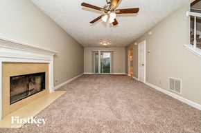 Jonesboro house for rent - an empty living room with a fireplace and a ceiling fan