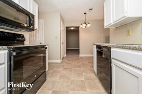 Jonesboro house for rent - a kitchen with stainless steel appliances and white cabinets
