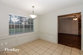 Houston house for rent - a dining room with a large window and a door to a hallway