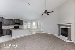 Haslet house for rent - a kitchen and living room with a fireplace and a ceiling fan