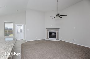 Haslet house for rent - a living room with a fireplace and a ceiling fan