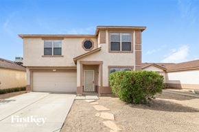 El Mirage house for rent - a beige house with a driveway and a garage door