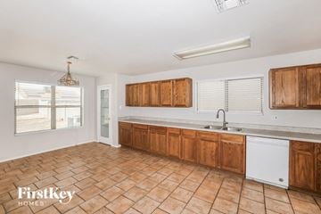 El Mirage house for rent - a large kitchen with wooden cabinets and a sink