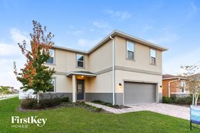 Riverview house for rent - a beige and orange house with a driveway and lawn