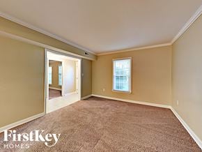 Charlotte house for rent - an empty living room with a door to a hallway and a window
