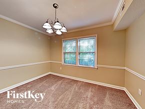 Charlotte house for rent - an empty dining room with a window and a chandelier