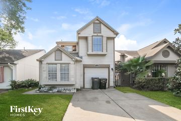 Houston house for rent - a white house with a garage and a driveway