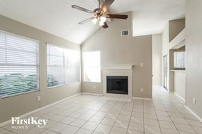 Houston house for rent - an empty living room with a ceiling fan and a fireplace