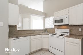 Houston house for rent - a kitchen with white appliances and white cabinets