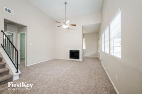 Houston house for rent - A spacious living room with a fireplace and a ceiling fan.