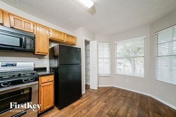 Houston house for rent - A kitchen with wooden cabinets and black appliances.