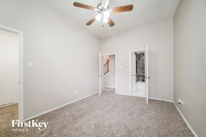 Houston house for rent - A spacious room with a ceiling fan and carpeted floor.