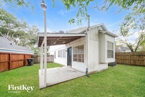 Houston house for rent - A house with a white exterior and a covered patio area is for sale.