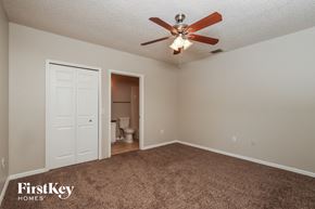 Sebastian house for rent - a bedroom with a ceiling fan and a door to the bathroom