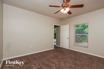 Sebastian house for rent - a living room with carpet and a ceiling fan