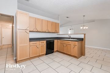 Port St. Lucie house for rent - a kitchen with wooden cabinets and a black counter top