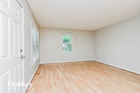 Florissant house for rent - A room with wooden flooring and a window showing greenery outside.