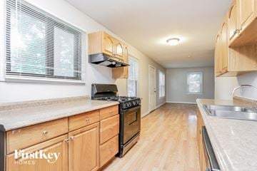 Florissant house for rent - A kitchen with wooden cabinets and a stove top oven.