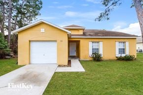 Sebastian house for rent - A yellow house with a white garage door and a brown roof.