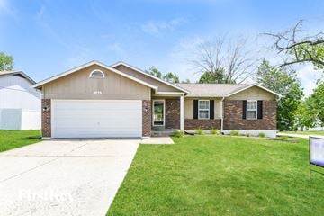 Florissant house for rent - a home with a white garage door and a lawn