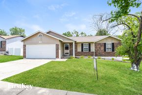Florissant house for rent - a home with a lawn and a white garage door