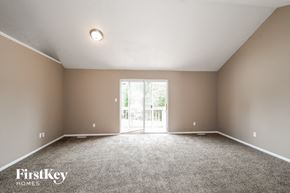 Florissant house for rent - the spacious living room with carpeted flooring and doors to the patio