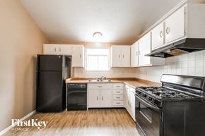 Florissant house for rent - an empty kitchen with black appliances and white cabinets
