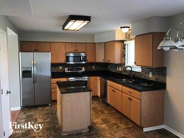 Blacklick house for rent - a kitchen with wooden cabinets and a stainless steel refrigerator