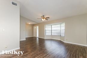 Wellington house for rent - A spacious room with wooden floors and a ceiling fan.