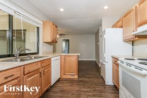 Wellington house for rent - A kitchen with wooden cabinets and a white refrigerator.