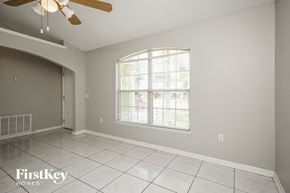 Kissimmee house for rent - an empty living room with a large window and a ceiling fan