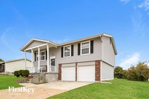 Black Jack house for rent - a beige house with a driveway and a garage door