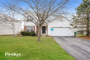Huntley house for rent - a white house with a driveway and a tree in front of it